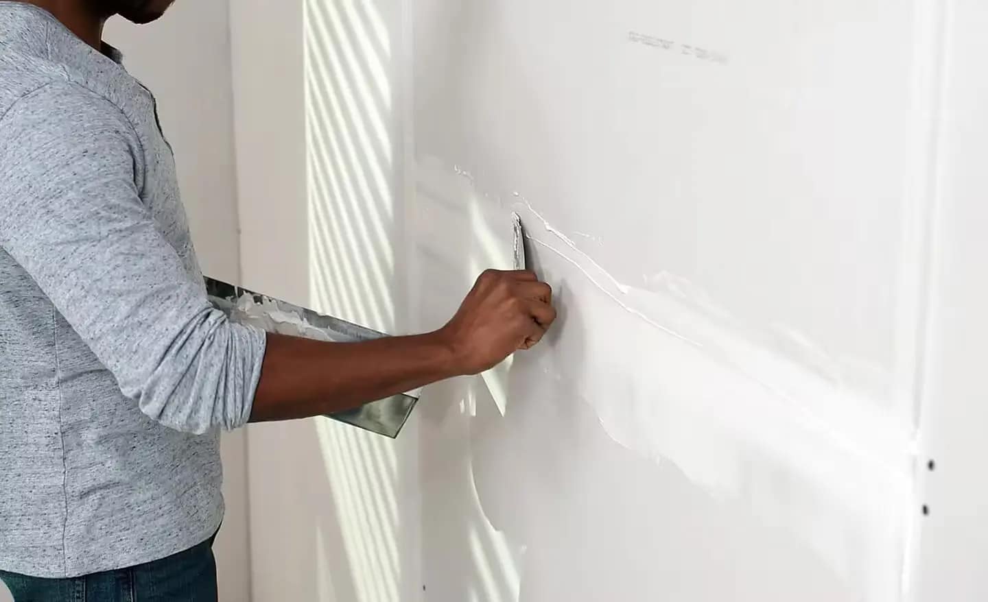 Joint compound spread smoothly over taped drywall joints with a taping knife
